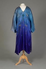 Probably American, ca. 1915-1925. Silk satin robe, light blue top shading to blue-purple at hem. Blue embroidered flowers with ribbons of couched gold thread. 