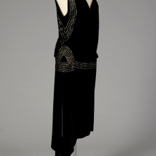 American, ca. 1920-1924. Black velvet with rhinestones. See the flounce at the hip as well as the decorated hip band. Also, the hemline is slightly longer than in later years.